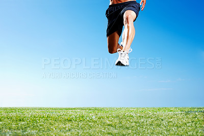 Buy stock photo Cropped image of a young guy jumping on the green grass against the sky - Copyspace
