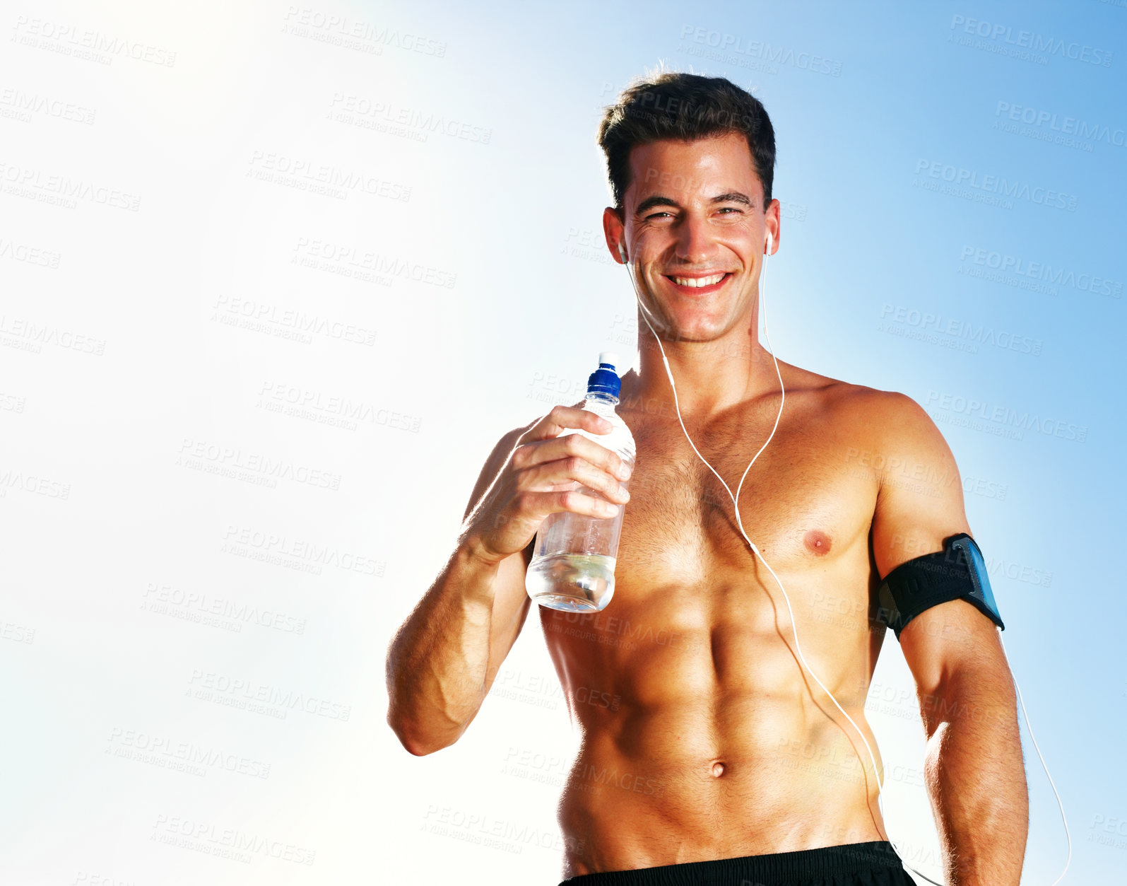 Buy stock photo Water, tired and man on field for workout, earphones and portrait with bottle and summer. Training, cardio and exercise for male person or athlete, running or park for fitness with music and sunlight