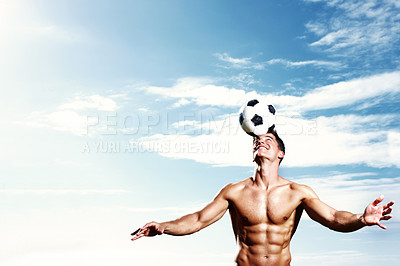 Buy stock photo Portrait of a masculine young man balancing soccer ball on his head against the sky
