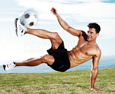 Buy stock photo Portrait of a young soccer player kicking the football in action against the sky
