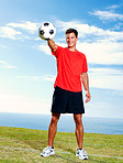 Happy male soccer player standing with a football