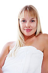 Smiling blond woman wrapped in a towel against white