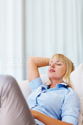 Buy stock photo Sleeping, relax and young woman on a sofa for peace after work with tiredness or exhaustion. Calm, rest and female person from Australia taking nap on couch in the living room at modern apartment.