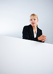 Confident female executive resting on wall