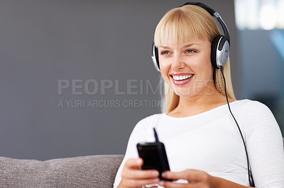 Buy stock photo Closeup of smiling young woman listening music through MP3 player