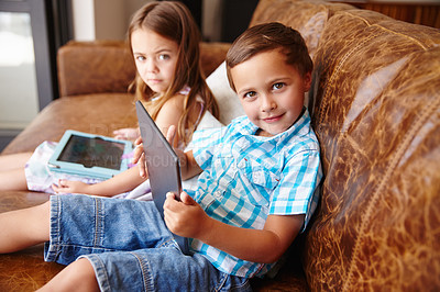 Buy stock photo Shot of a brother and sister using a digital tablet at home