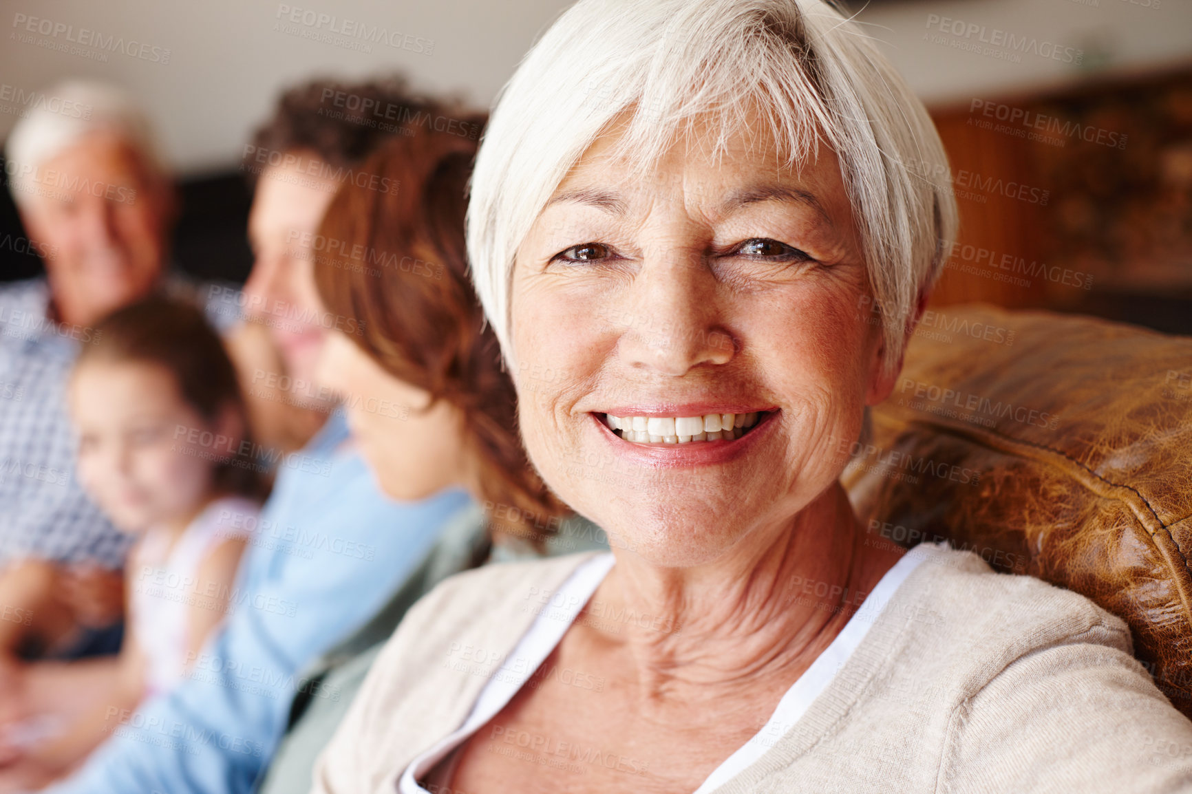 Buy stock photo Portrait of a senior woman sitting on the sofa with her family