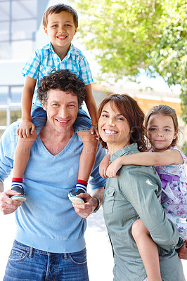 Buy stock photo Shot of a mother and father giving their two children piggyback rides