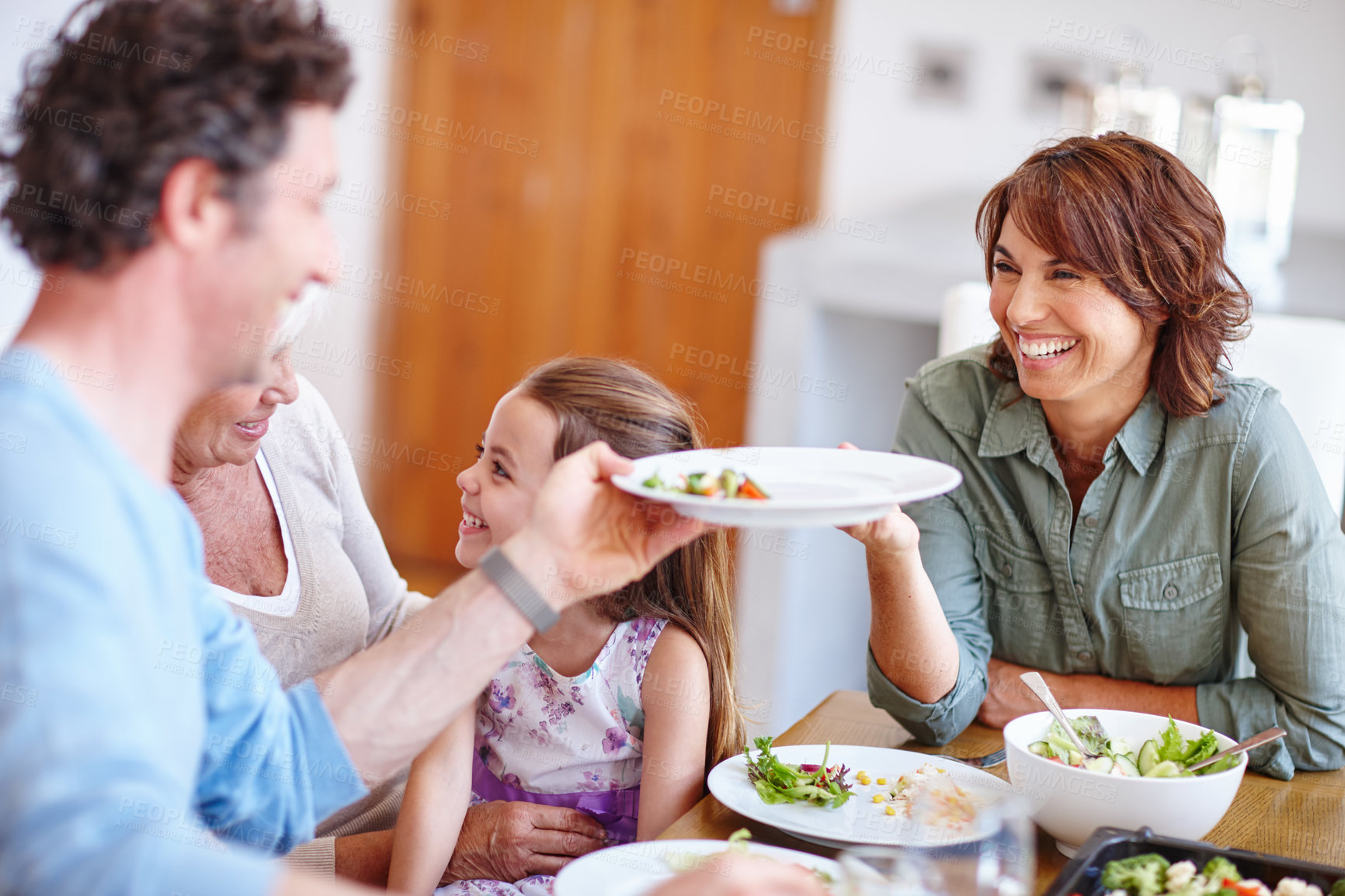 Buy stock photo Family, meal and girl with salad, home and bonding together with social gathering. Apartment, grandma or mother with daughter, father or nutrition with lunch, smile or celebration with food and break