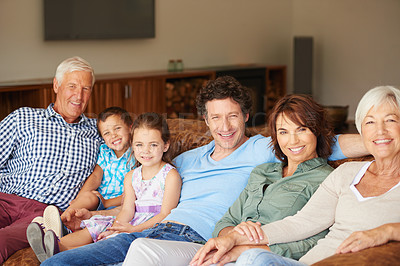 Buy stock photo Shot of a happy multi-generational family sitting together on a sofa