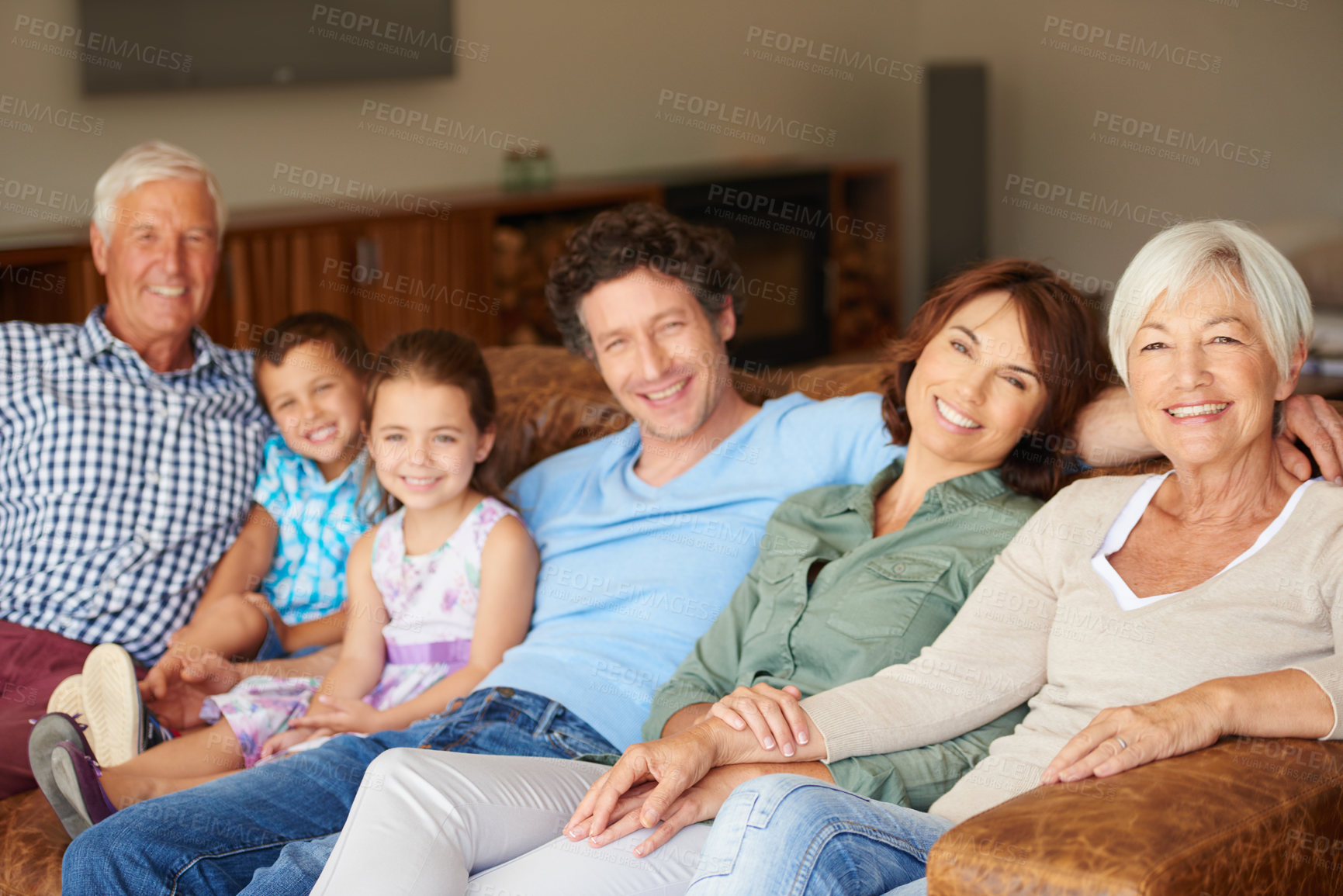 Buy stock photo Shot of a happy multi-generational family sitting together on a sofa