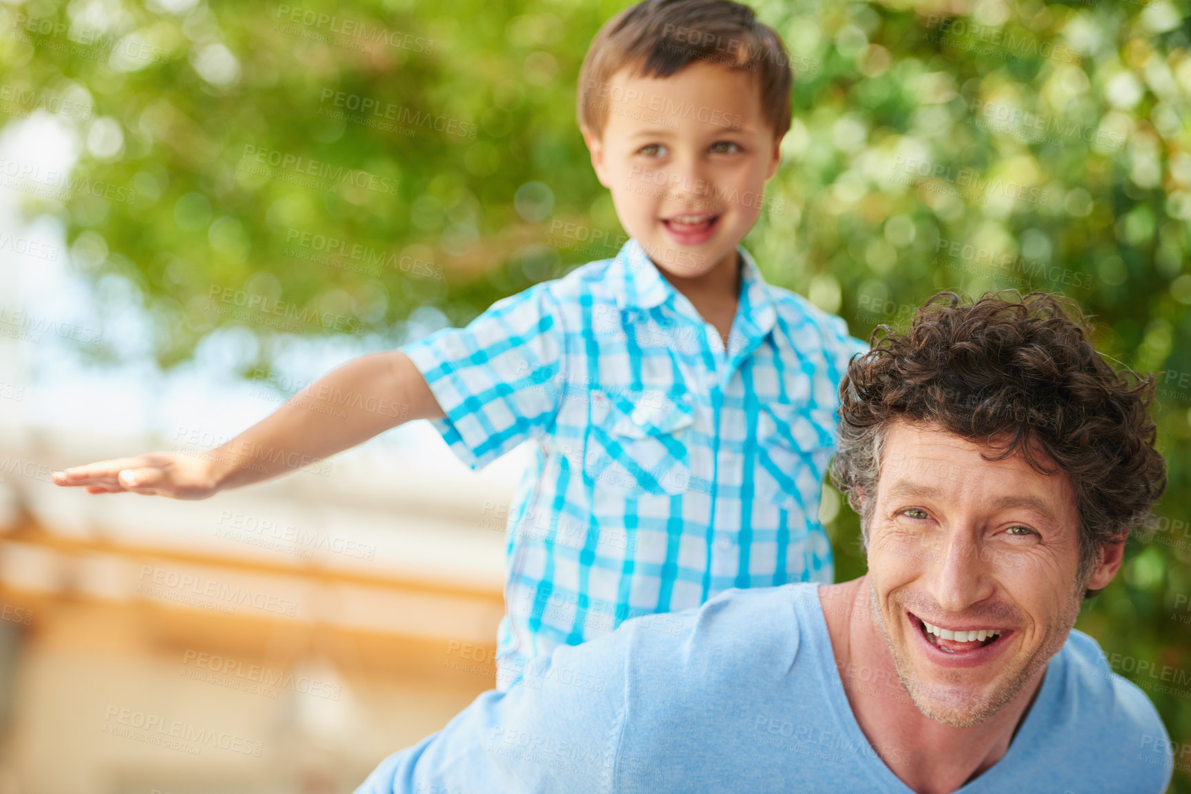 Buy stock photo Portrait of a father giving his son a piggyback ride outside