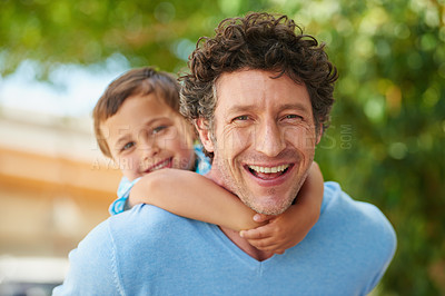 Buy stock photo Portrait of a father giving his son a piggyback ride outside