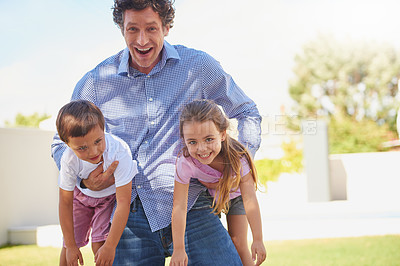 Buy stock photo Shot of a father playing with his son and daughter in the backyard