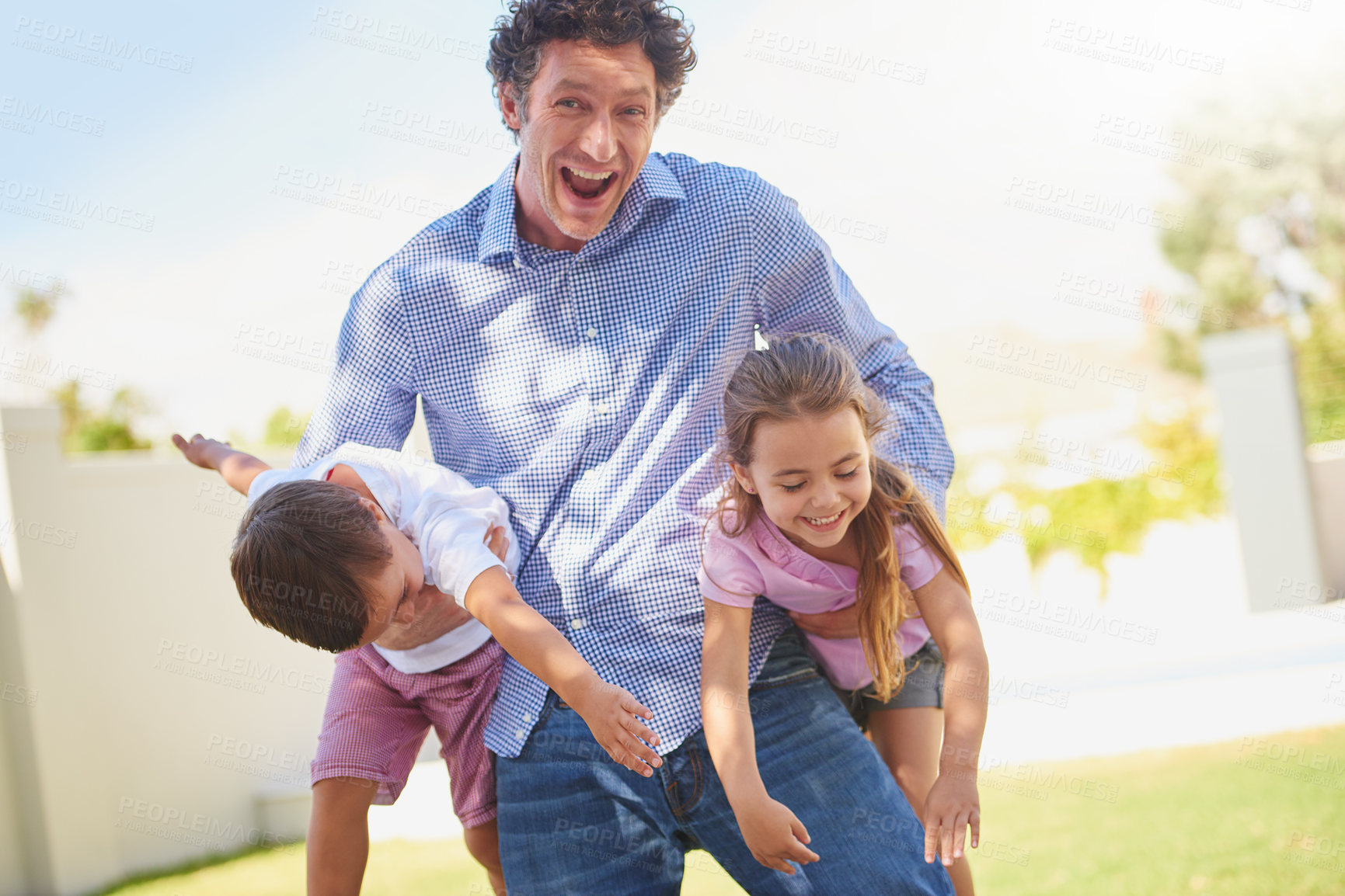 Buy stock photo Father, playful and carry children in backyard, portrait and excited for games, love or care in summer. Man, dad and kids with joke, laugh and fun for bonding on lawn at family house in New Zealand