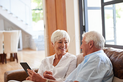 Buy stock photo Shot of a senior couple using a digital tablet at home