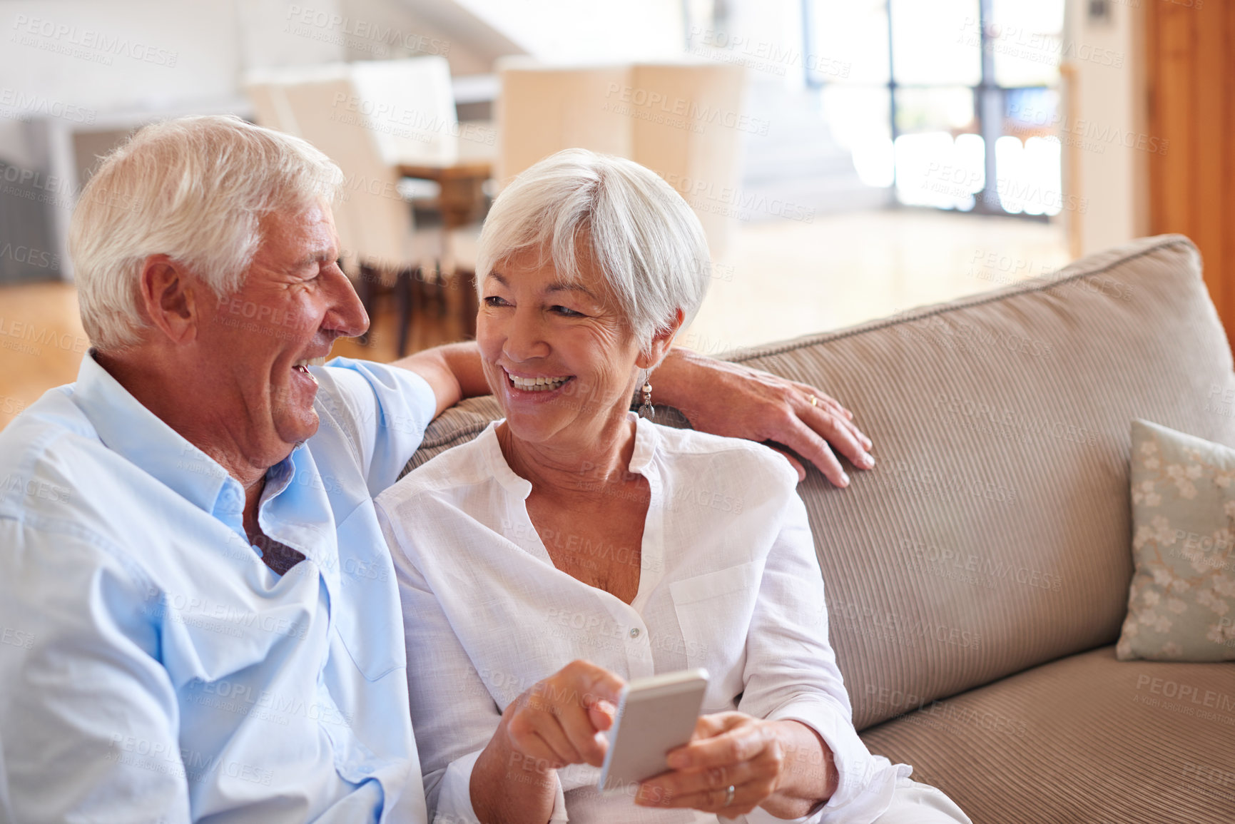 Buy stock photo Shot of a senior couple using a cellphone together