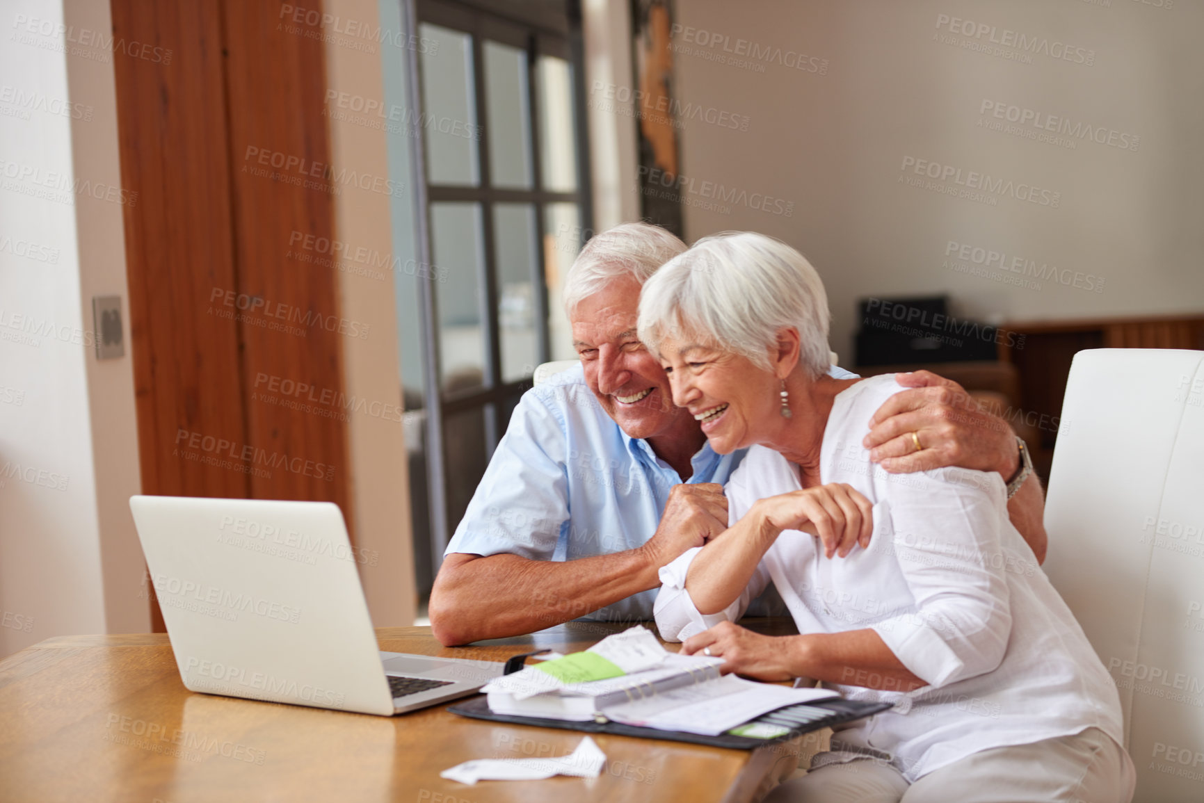 Buy stock photo Shot of a senior couple going over some paperwork while using a laptop