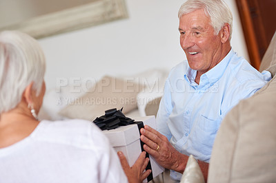 Buy stock photo Shot of a senior man giving his wife a gift