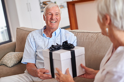 Buy stock photo Shot of a senior man giving his wife a gift