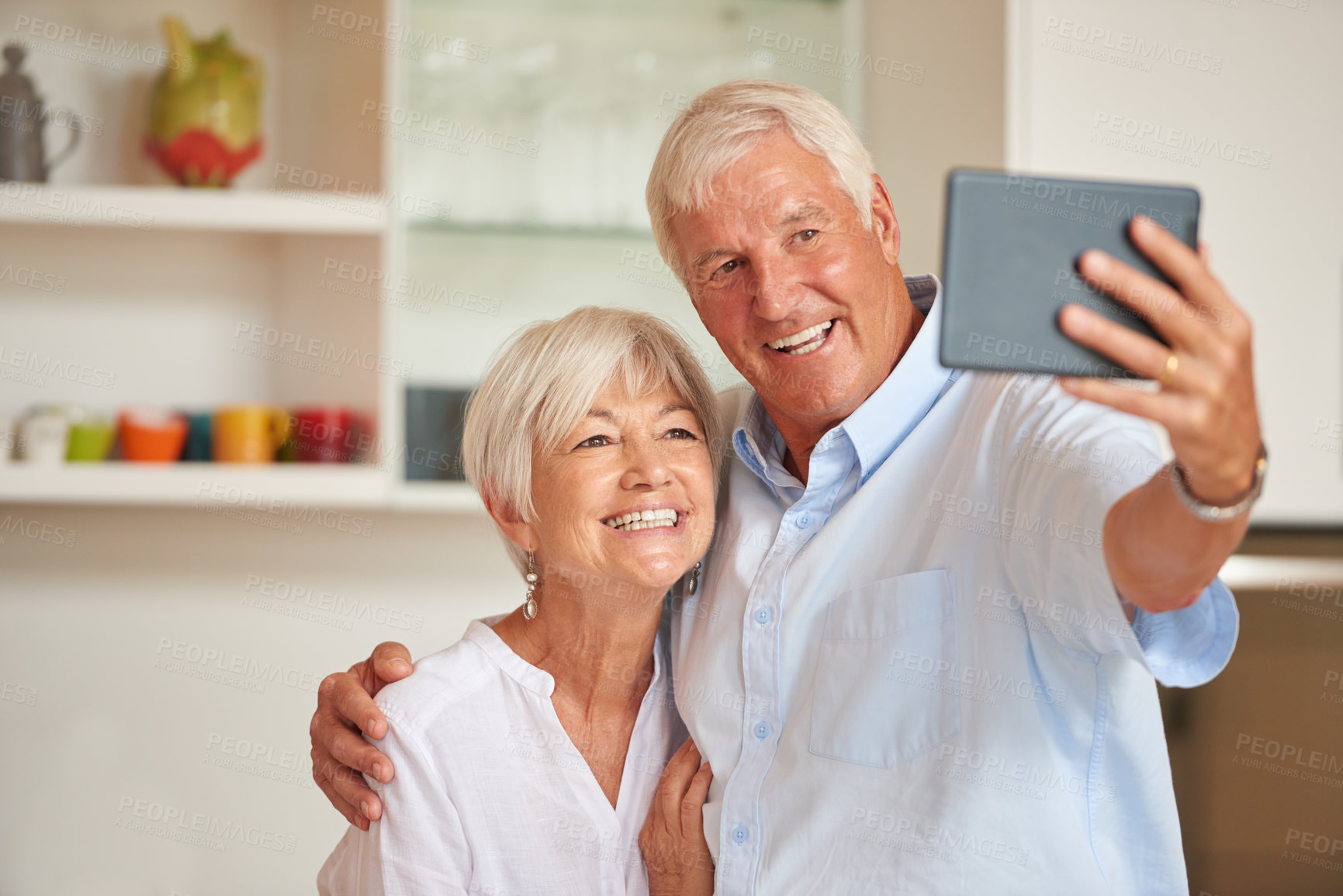 Buy stock photo Shot of a senior couple taking a selfie with their tablet