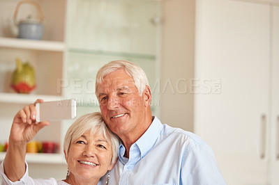 Buy stock photo Shot of a senior couple taking a selfie with their cellphone
