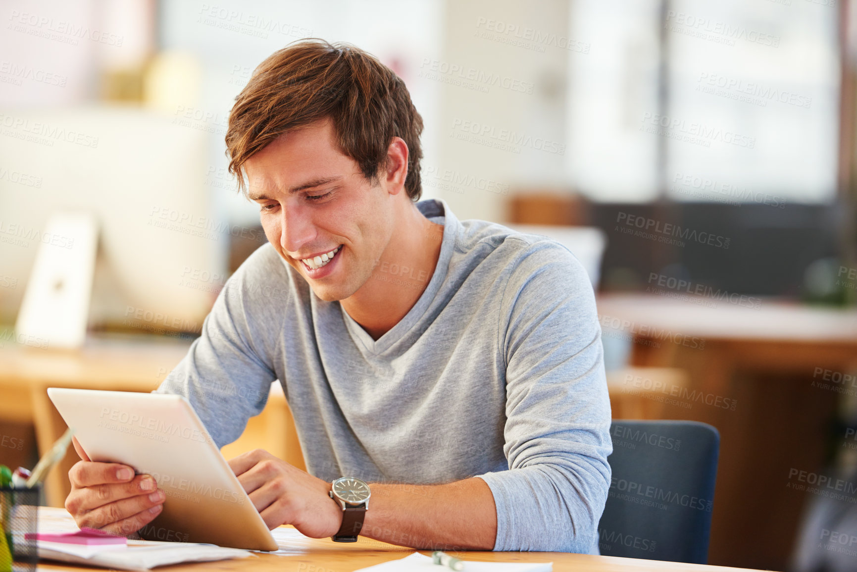 Buy stock photo Shot of a designer using a digital tablet while working in an office