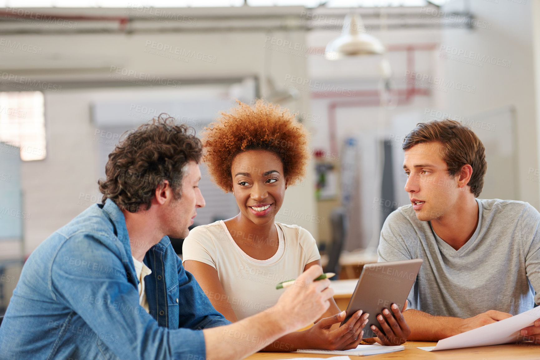 Buy stock photo Shot of a group of colleagues  using a digital tablet together in an office