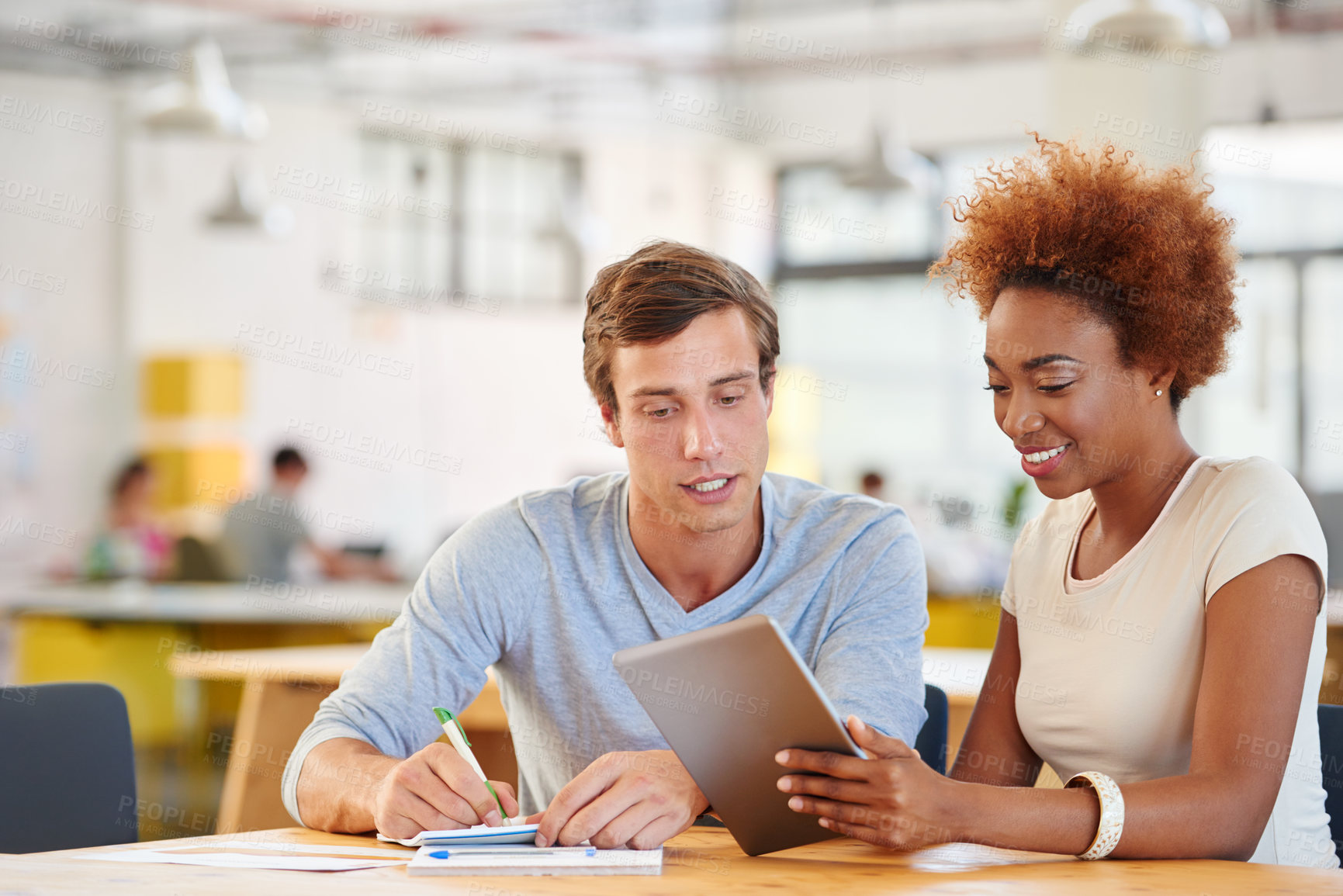 Buy stock photo Shot of two coworkers using a digital tablet together in an office