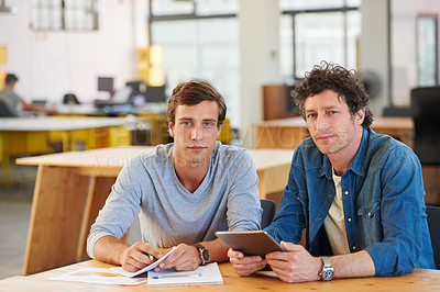 Buy stock photo Shot of two coworkers using a digital tablet together in an office