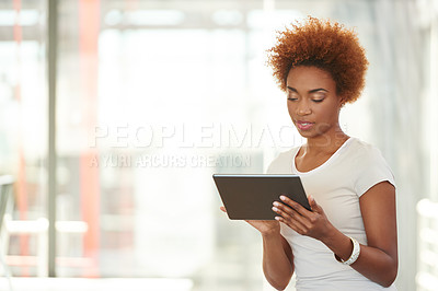 Buy stock photo Shot of a young businesswoman using a digital tablet in the office