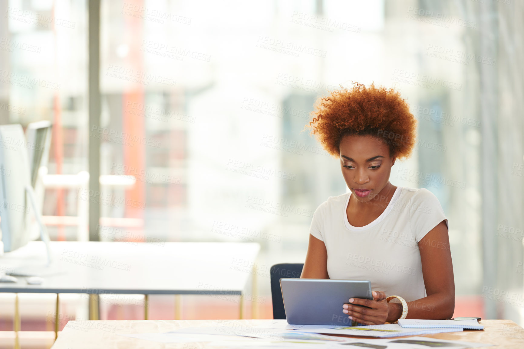 Buy stock photo Shot of a young businesswoman using a digital tablet in the office