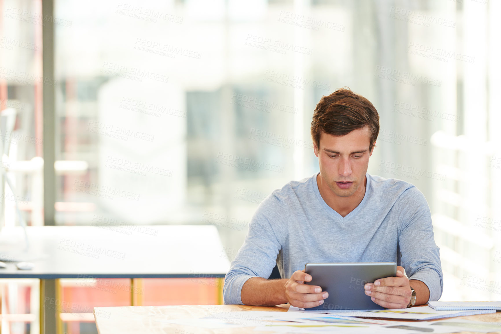 Buy stock photo Shot of a designer using a digital tablet while working in an office