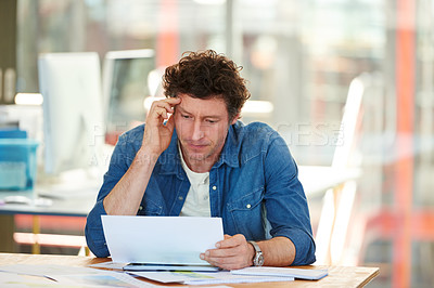 Buy stock photo A young man working on a digital tablet in the office