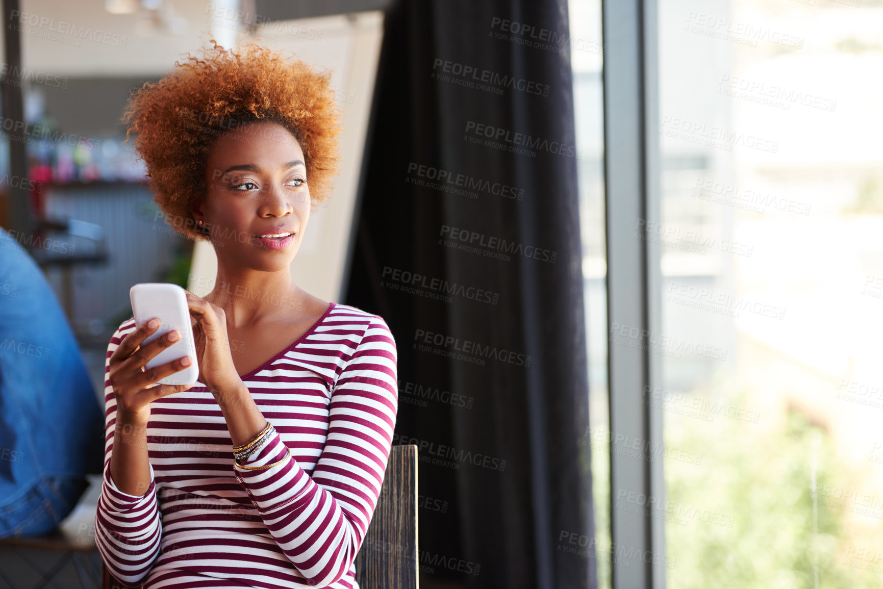 Buy stock photo A young businesswoman using her phone in the office