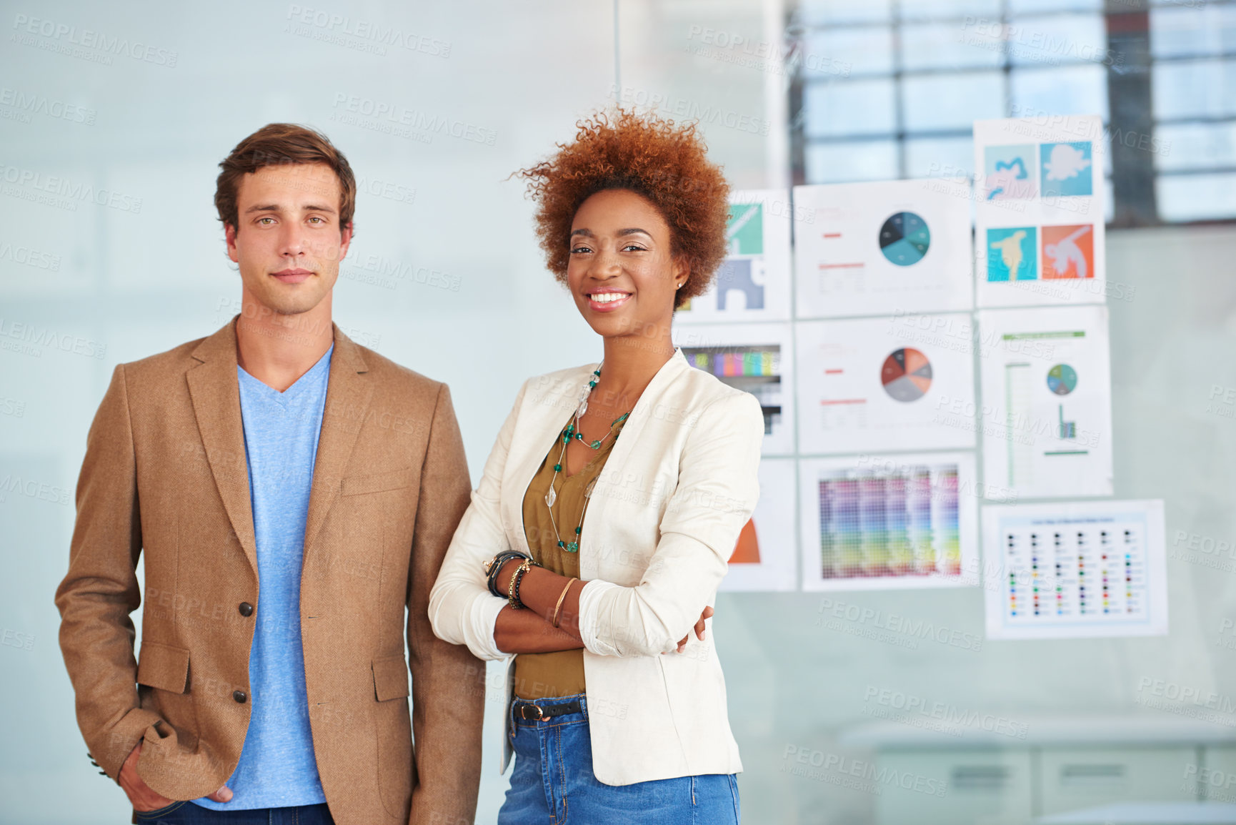 Buy stock photo Portrait of a two confident young coworkers standing together in an office