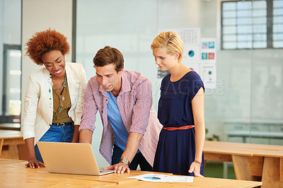 Buy stock photo Shot of young coworkers working together on a laptop together