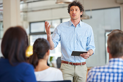 Buy stock photo Shot of designer giving a presentation to his colleagues using a digital tablet