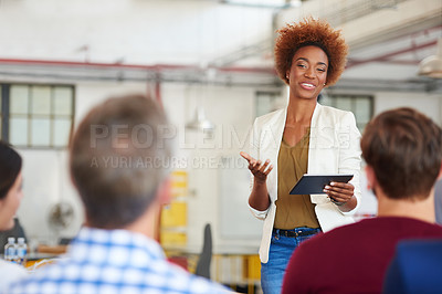 Buy stock photo A woman giving a presentation to her colleagues using a digital tablet