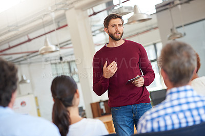 Buy stock photo Shot of designer giving a presentation to his colleagues using a digital tablet