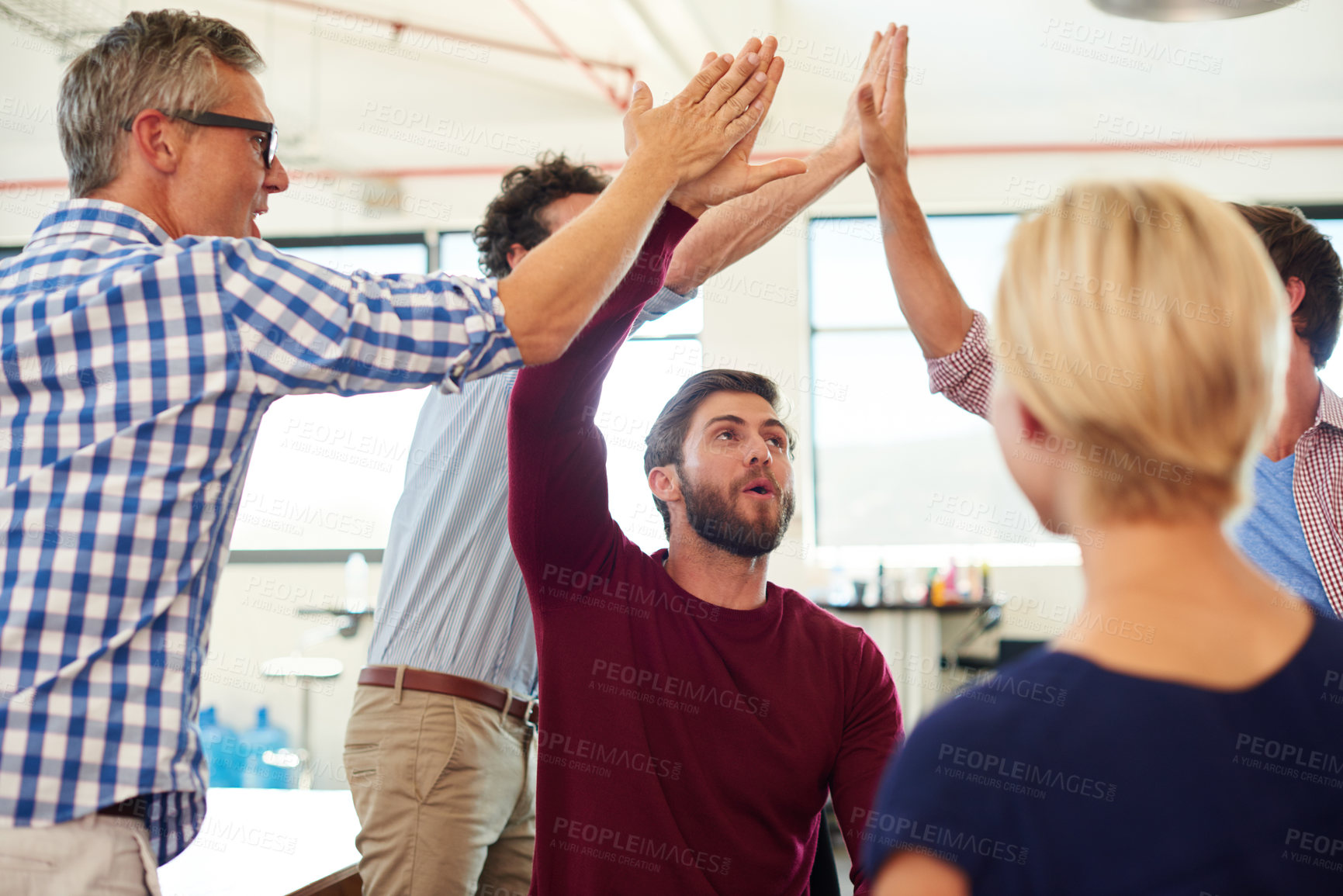 Buy stock photo Shot of a group of designer high-fiving each other during an informal meeting