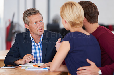 Buy stock photo Young couple discussing investment plans with a financial advisor