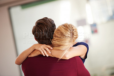 Buy stock photo Shot of a couple hugging together in an open office