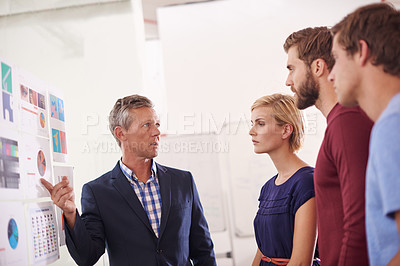 Buy stock photo Shot of a man presenting data to his colleagues