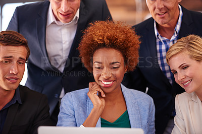 Buy stock photo Cropped shot of a group of businesspeople gathered around a single laptop