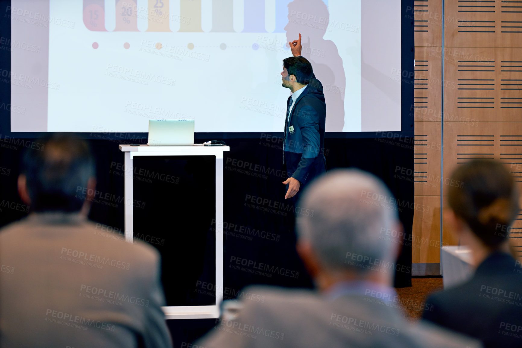 Buy stock photo Businessman, presentation and podium with projector at conference in team meeting, staff training or seminar. Man, employee or speaker talking to group or audience with screen at corporate workshop