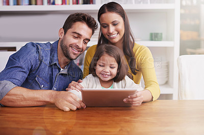 Buy stock photo Mom, dad and kid at table with tablet for teaching, learning and support in education with love. Elearning, digital app and parents with girl child for homeschool movie, growth and development online