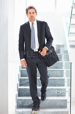 Buy stock photo Full length of a smart business man walking down the stairs with an office bag