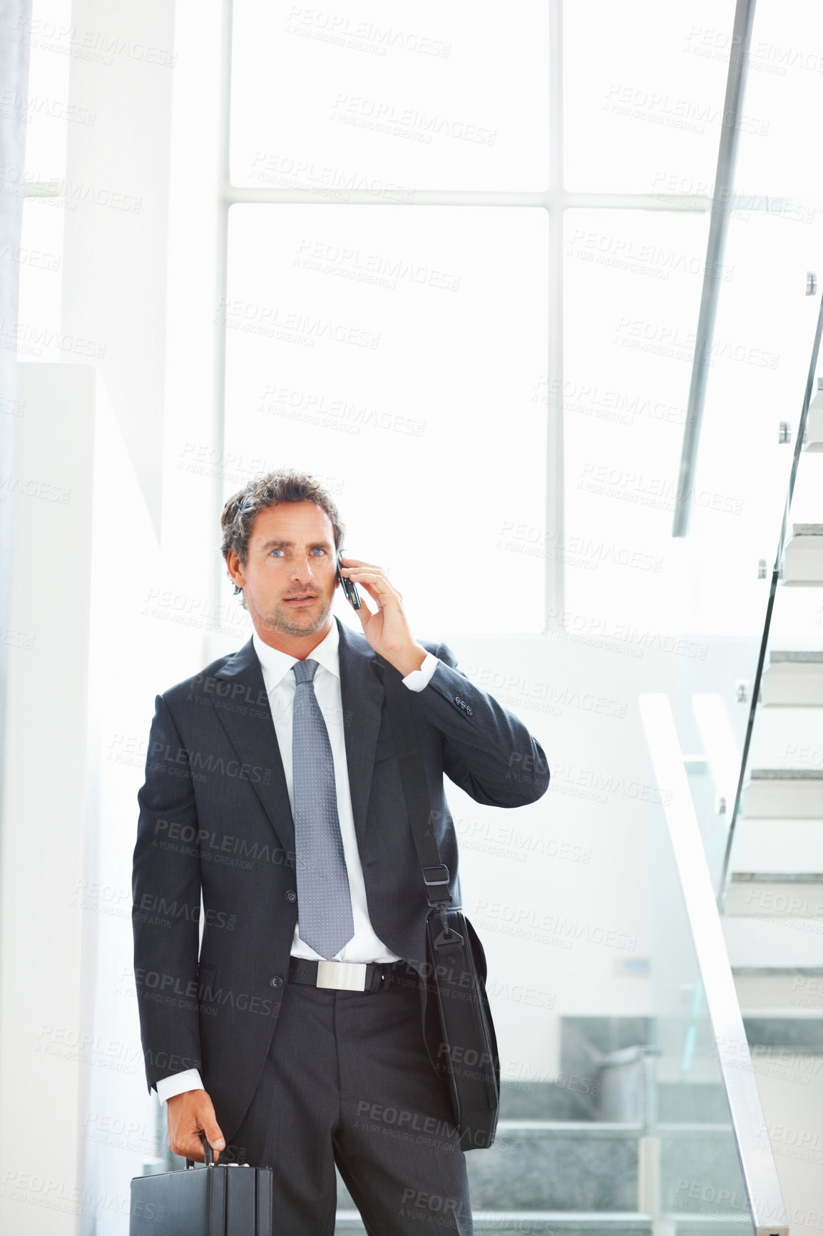 Buy stock photo Business man, phone call and talking on stairs in office, networking and consultant for planning. Male person, communication and steps for deal negotiation, briefcase and leave work for connection