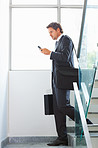 Business man using cellphone on stairs